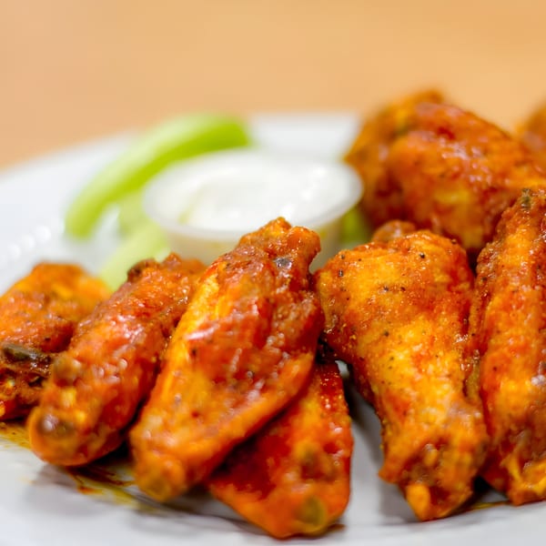 Goofy's Grill's buffalo wings, served with celery sticks and a side of ranch dressing.