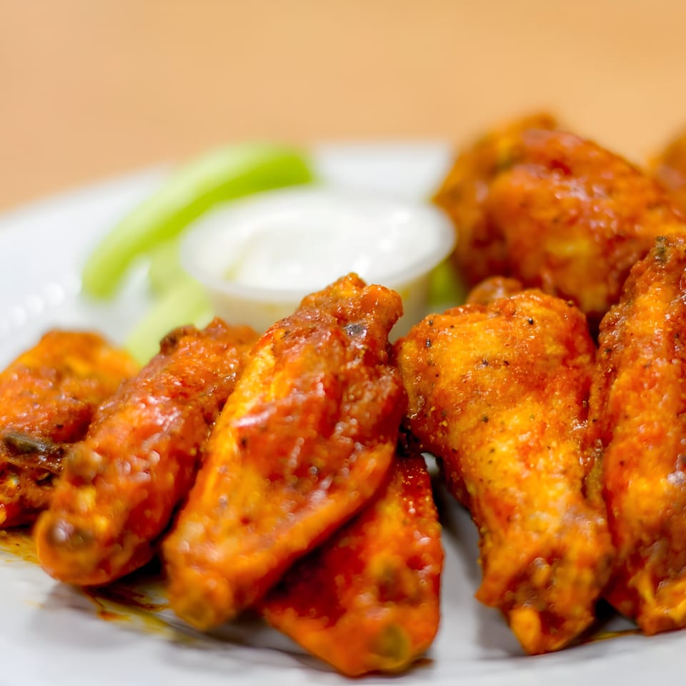 Goofy's Grill's buffalo wings, served with celery sticks and a side of ranch dressing.